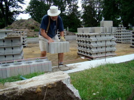 Setting  a block into the mortar on the footing.