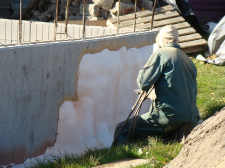 Rick spraying the foam on the foundation wall.