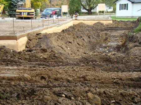 Backfilling along the south wall of the house foundation.