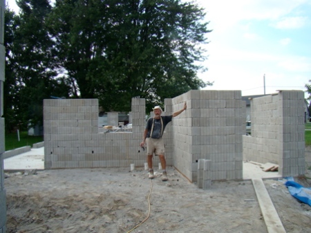 Tuesday afternoon Aug 25, finished stacking east, west, and north walls to top of window frames. Beginning to really look like a house.